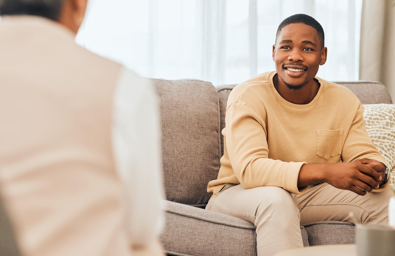 Happy patient talking to psychiatrist at a therapy session.