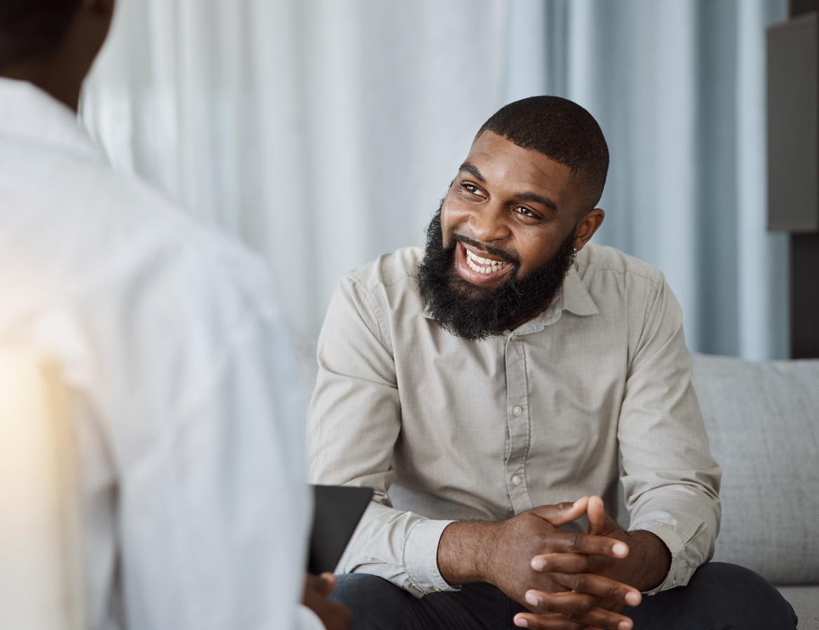 Happy man, therapist and consultation in meeting for healthcare, mental health.